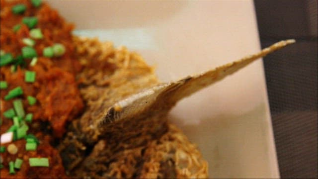 소스와 채소가 얹힌 생선 튀김