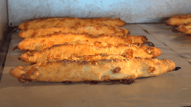 Freshly baked baguettes coming out of oven