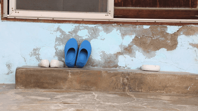 Old house entrance with blue slippers
