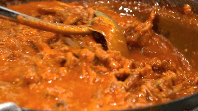 Spicy braised chicken feet in sauce simmering in a pot