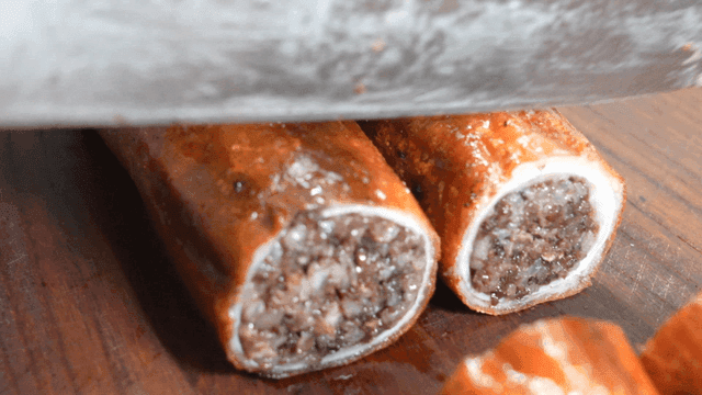 Makchang sundae being sliced on cutting board