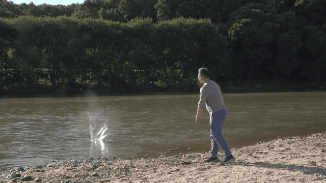 강가에서 돌을 던지는 남자