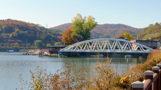 Serene Baegunhosu Lake with a bridge and autumn foliage