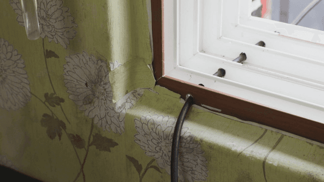 꽃무늬 벽지와 케이블이 있는 창문