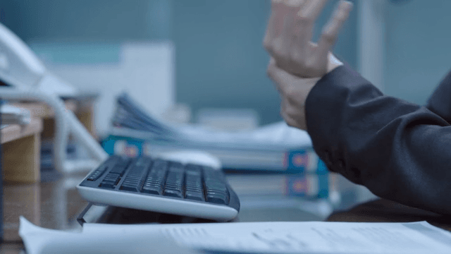 Hands stretching their wrists while typing