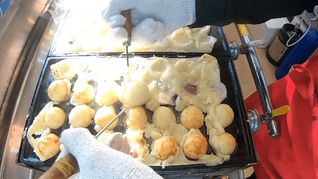 Cooking octopus balls on a hot griddle