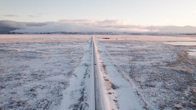 Snowy road stretching through a vast landscape