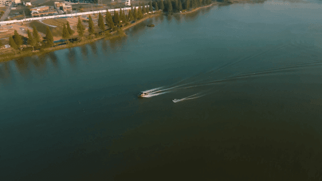 Boat skis crossing tranquil lake
