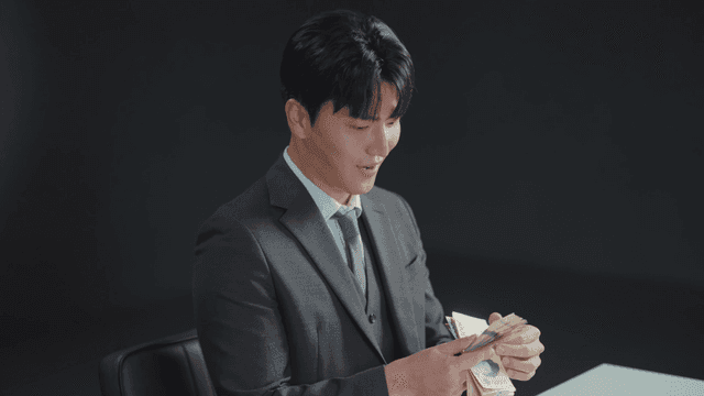 정장을 입은 남자가 돈을 세는 모습