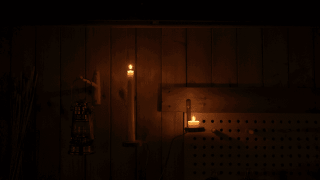 어두운 나무 벽에 켜진 촛불