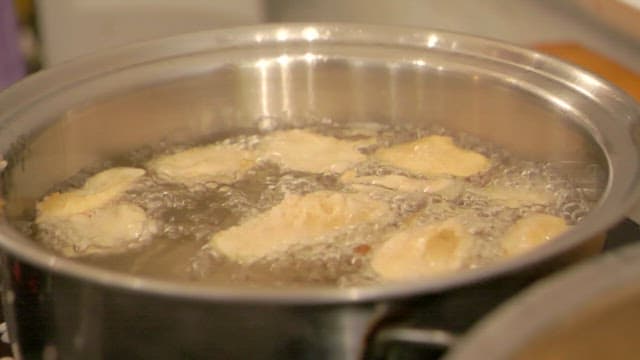 Ginseng pieces fried in boiling oil in a pan