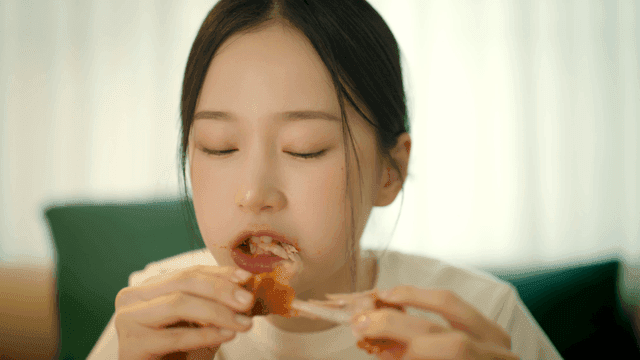 Woman eating seasoned chicken legs at home