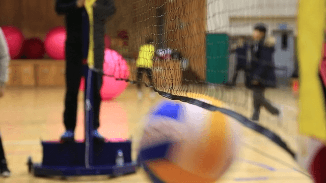 학교 체육관에서 배구 연습을 하는 학생들