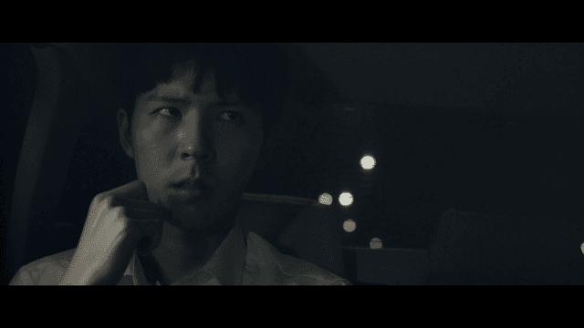 Student in a car at night looking thoughtful