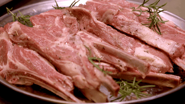 Raw lamb chops seasoned with herbs