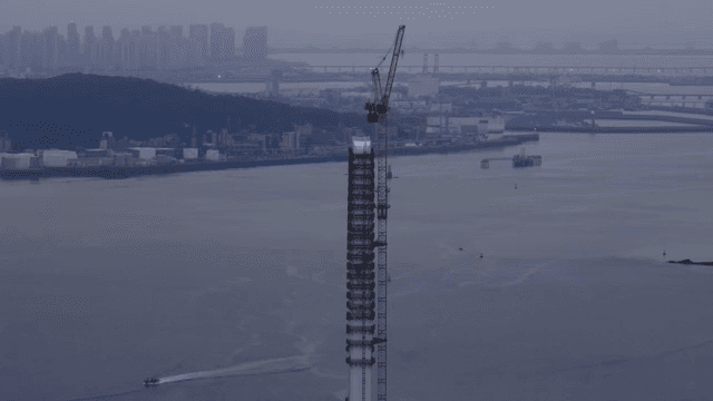 강가의 건설 중인 크레인과 건물