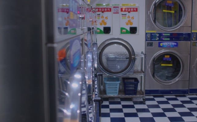 코인빨래방에 앉아 비눗방울을 불고 있는 두 여자