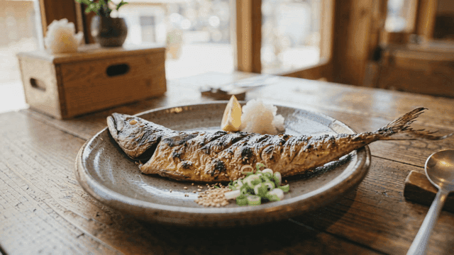 Grilled mackerel served with lemon and garnish