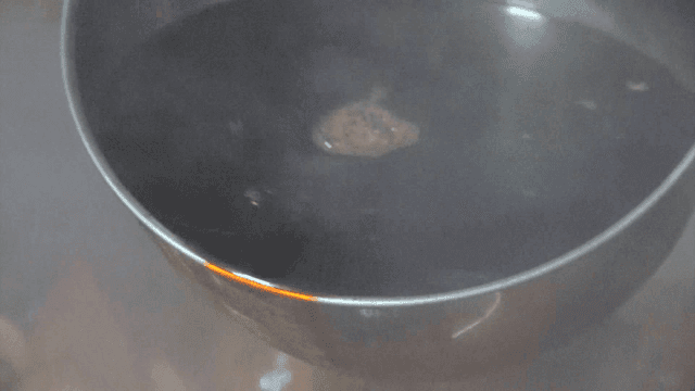 Ladle scooping soy sauce simmered with fruits and medicinal herbs