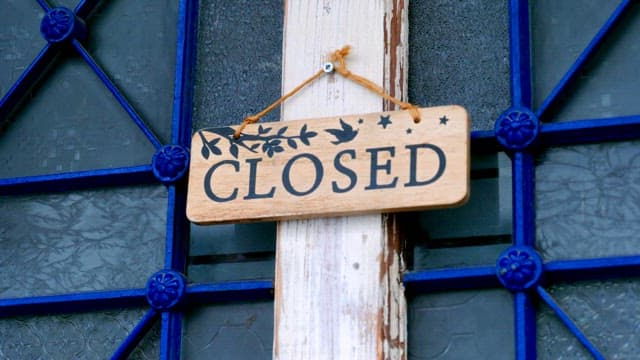 Closed sign on a blue-framed window