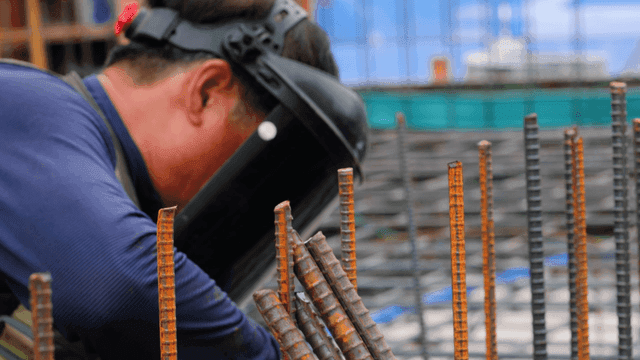 금속 막대를 용접하는 건설 노동자