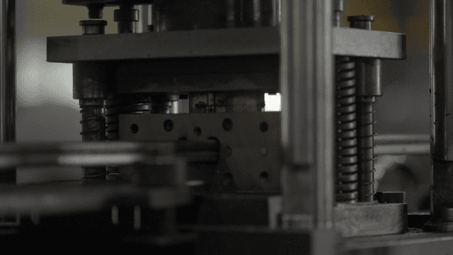 작동 중인 금속 프레스 기계의 근접 촬영