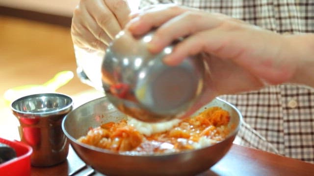 그릇 안에 있는 김치찌개에 밥을 비비는 모습