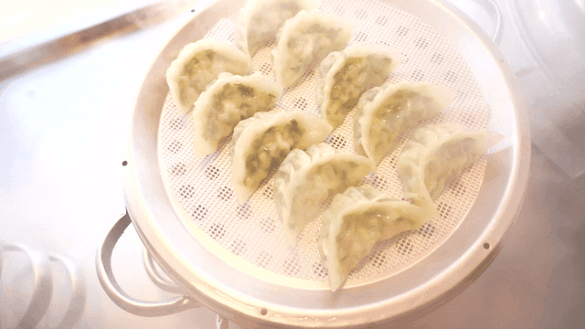 Hand opening lid of steamed dumpling