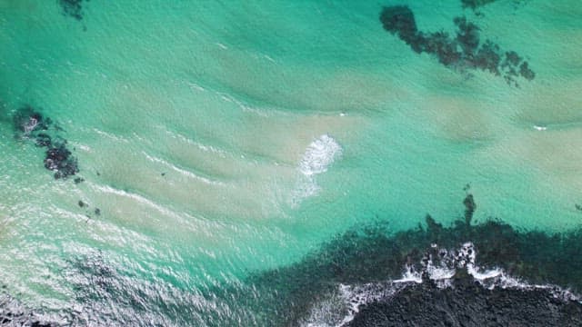 Aerial View of a Rocky Coastline and Clear Waters