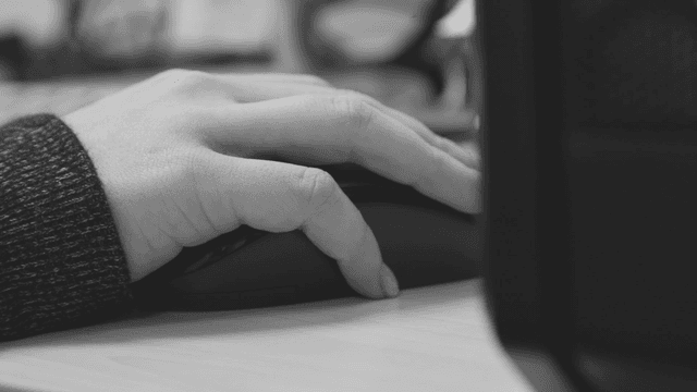 Hand on a computer mouse in an office