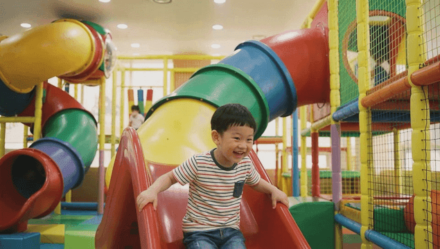 Boy coming down slide at kids' cafe