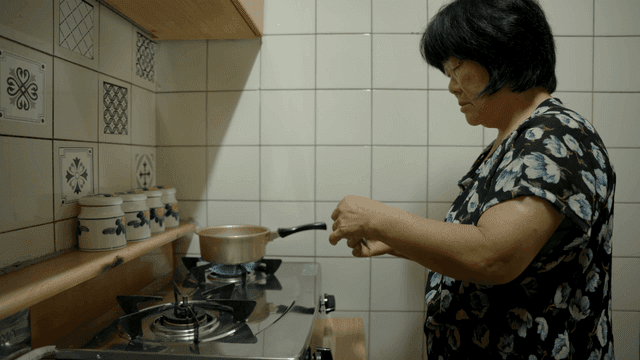 부엌에서 요리하는 노인 여성