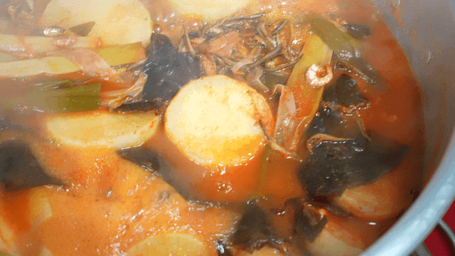 Pot of boiling stew with vegetables