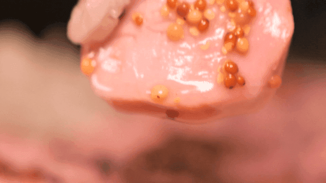 Pink sous vide sirloin slices topped with whole-grain mustard