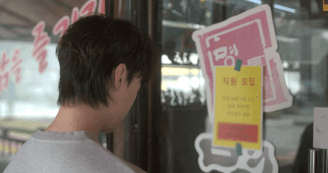 Back view of man looking at job posting on door