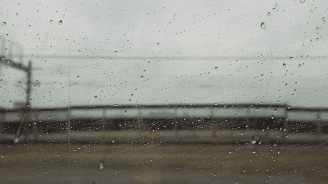 기차 창문에 맺힌 빗방울과 흐릿한 풍경