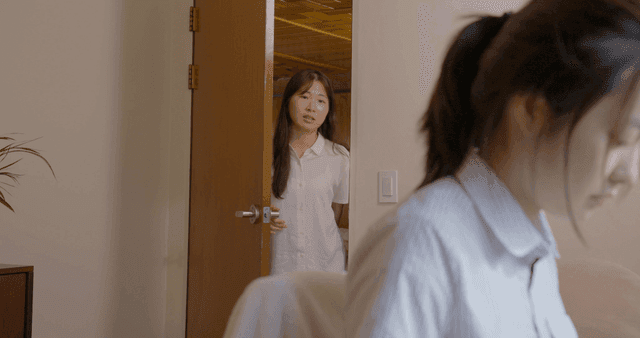 문을 잡고 앉아 있는 소녀에게 말을 거는 소녀