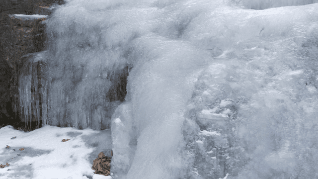 Frozen waterfall with icicles and snow
