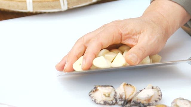 Garlic being prepared and cooked in a pan