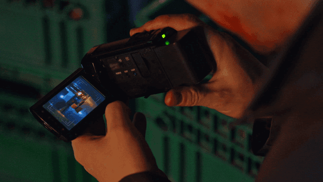 어두운 곳에서 캠코더 화면을 보는 남자