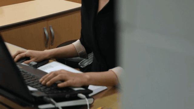 책상에서 노트북으로 작업을 하는 여성의 손