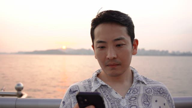 Man using a smartphone by the sea