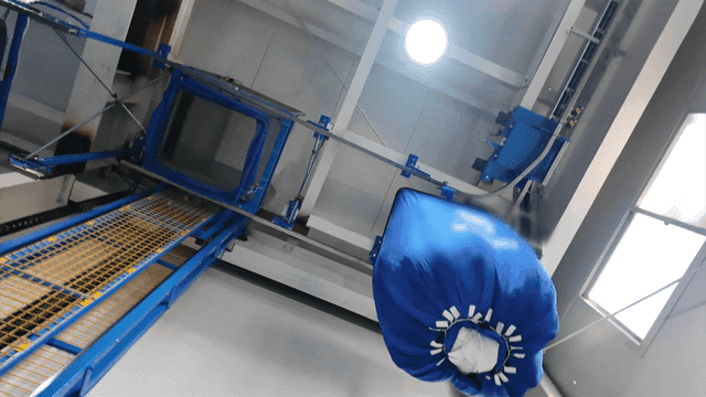 Laundry factory machine moving stacks of white fabric