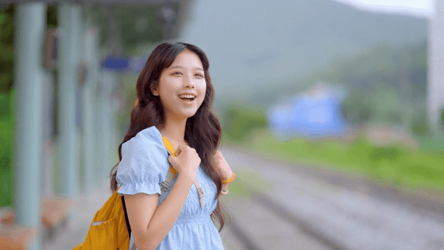 기차역에서 미소 짓는 젊은 여성