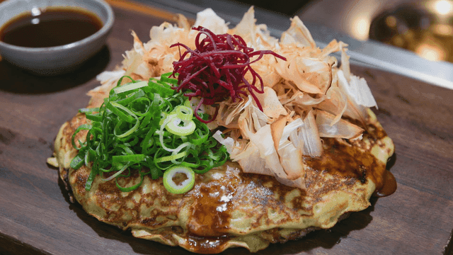 Okonomiyaki topped with fresh ingredients