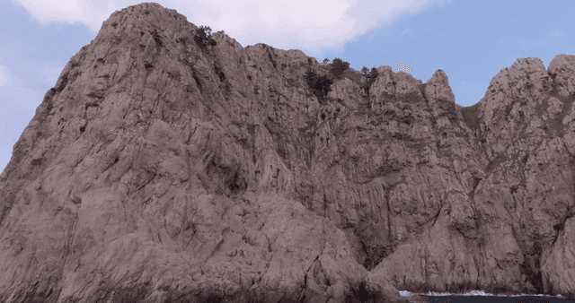 Rocky cliffs by the sea under a clear sky