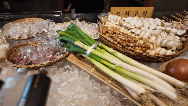 Fresh seafood, vegetables and skewers on ice