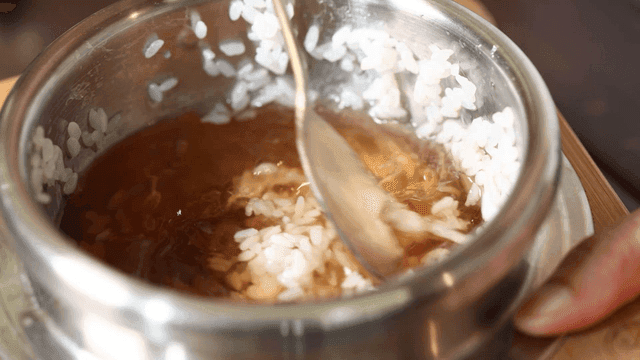 Scorched rice stirred in pot with water
