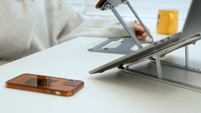 Person Putting Down Glasses and Picking Up Smartphone