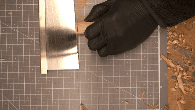 작업대에서 톱으로 나무 자르는 손